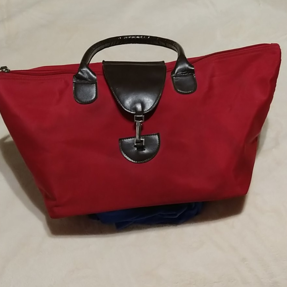 Red bag with brown leather like handle.